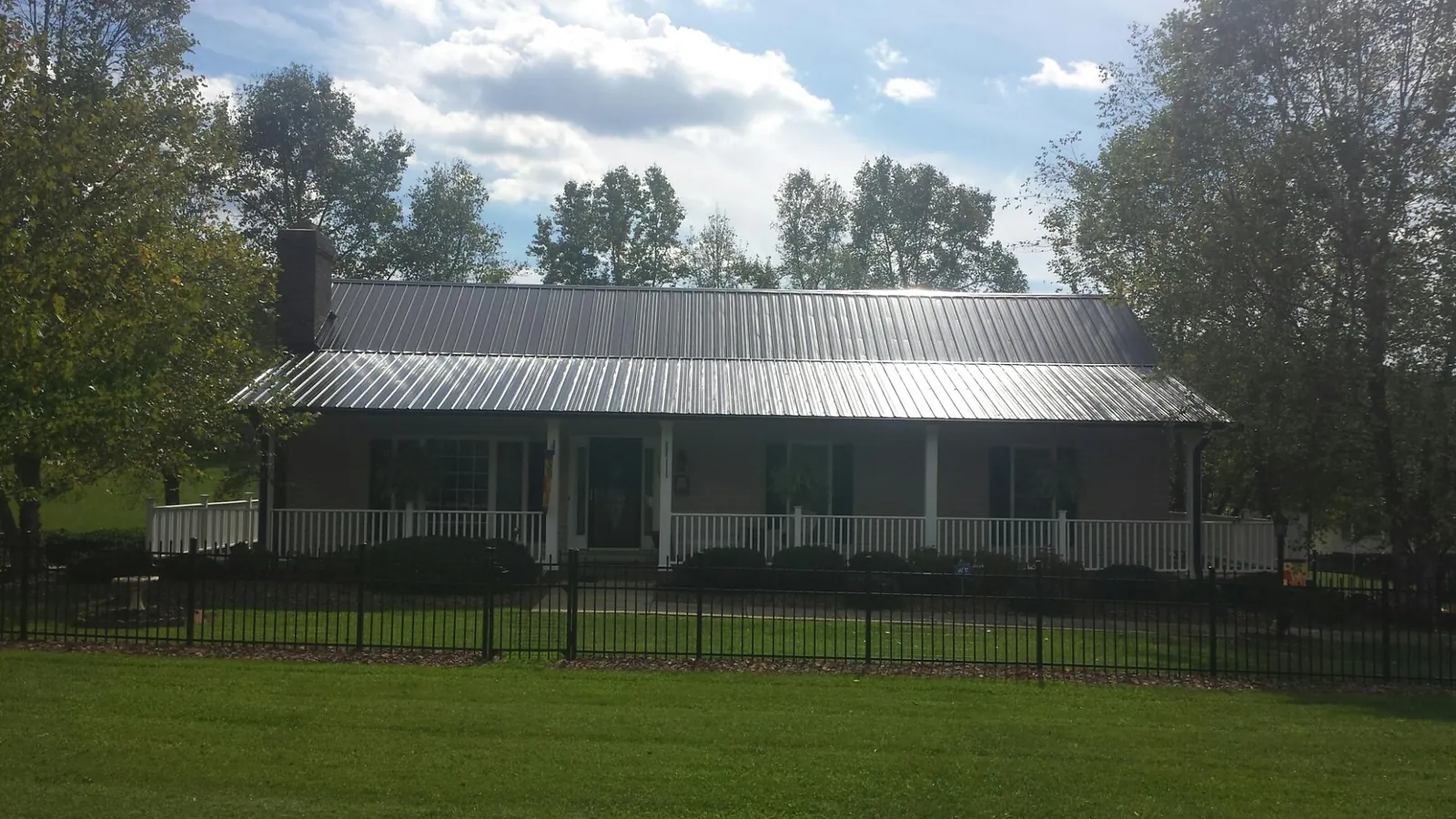 Gray metal roof on a brick ranch with a full width front porch — Gutter Guard Installation work by our crew in Gibsonia