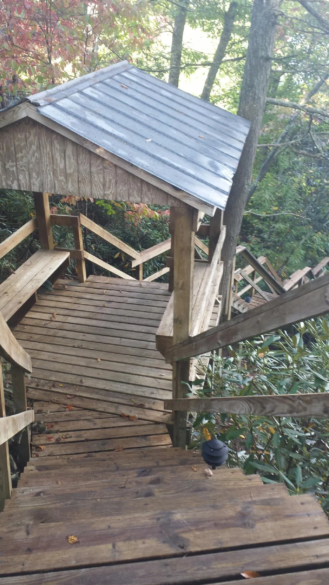 Metal roofed shelter over wooden steps on a wooded walkway — Skylight Repair & Installation work by our crew in Gibsonia